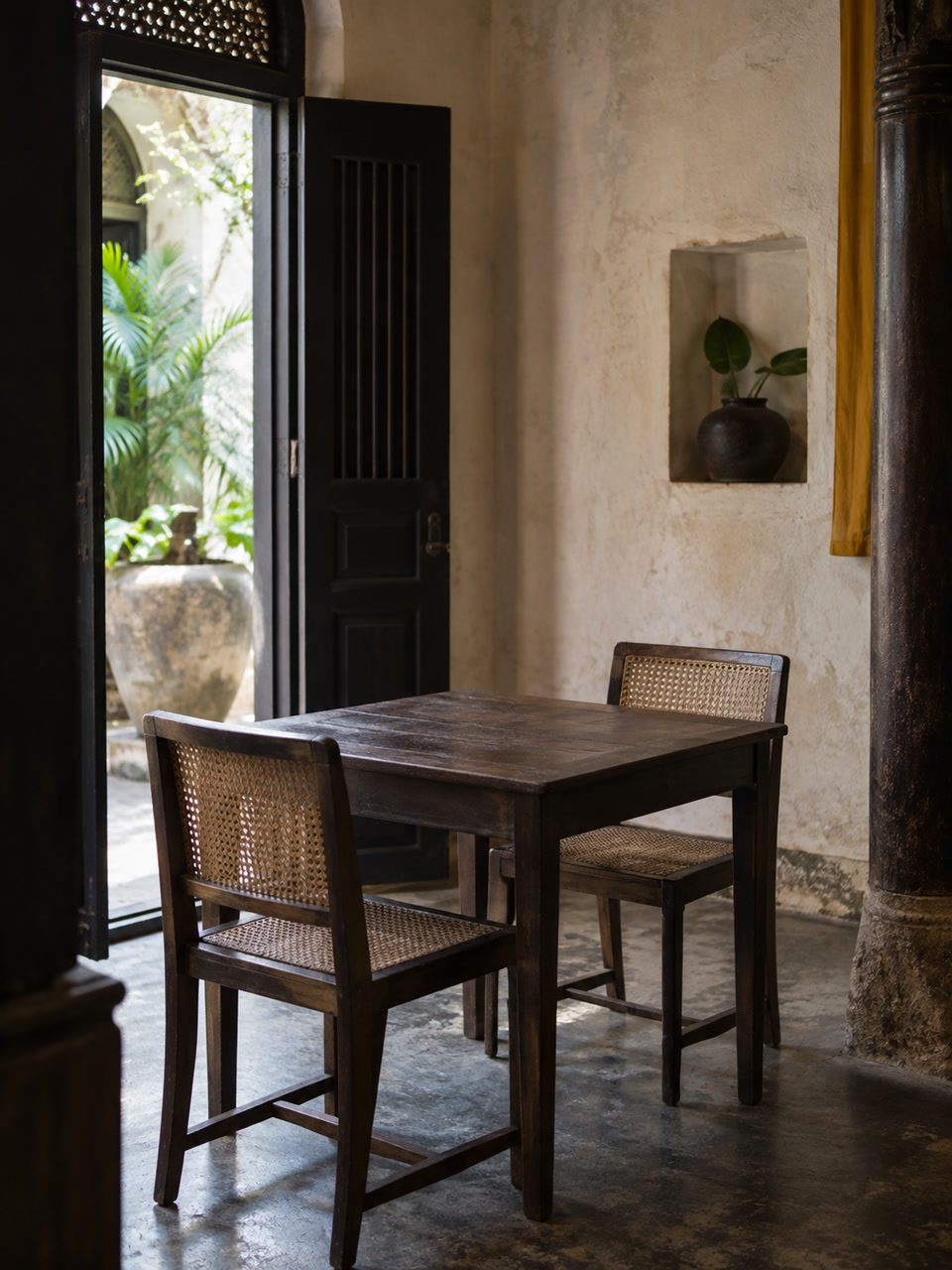 Empty wooden table in a small Fort dining room, lime-wash and timber